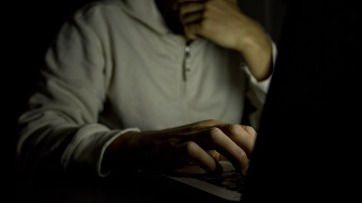 shutterstock_man on computer dark room